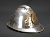 a silver helmet with a gold emblem on it