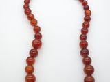 a necklace made of carnel beads on a white surface