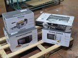 trois cartons de micro-ondes sur une palette dans un entrepôt