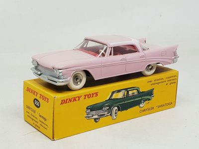 pink toy car sitting on top of a box on a white surface