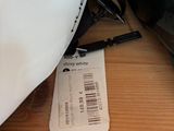 a white helmet on a table next to a black helmet