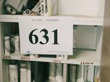 une étagère sur laquelle sont posés de nombreux objets, avec une étiquette indiquant « 631 »