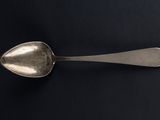 a spoon that is sitting on a black surface