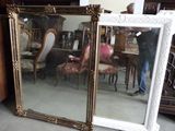 un grand miroir posé par terre à côté d'une chaise