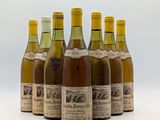 six bouteilles de vin sont alignées sur une surface blanche