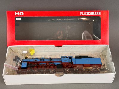 un train bleu et rouge dans une boîte posée sur une table