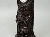 une statue représentant un homme tenant une horloge à la main