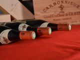 several bottles of wine are lined up on a red table cloth