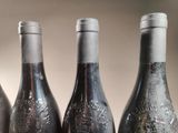 four bottles of wine are lined up on a table