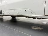the rear end of a white car with holes in it