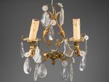 a gold chandelier with two candles and a candle holder
