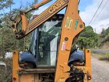 a backhoe of a tractor that is parked on the side of the road