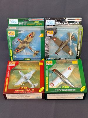 trois boîtes contenant des avions miniatures, posées sur une table