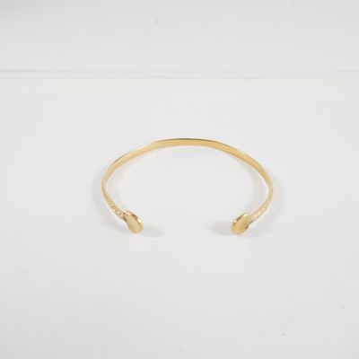 un bracelet manchette en or orné de deux petites perles