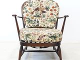 a chair with a floral upholstered seat and a bird on it