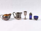 three silver and blue glass items are sitting on a white surface