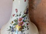 a white vase with a floral design on it