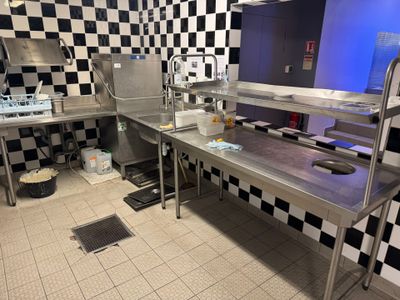 a kitchen with a checkered wall and stainless steel counter tops