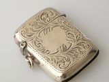 an antique silver cigarette case on a white surface