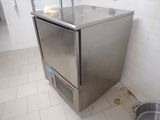 a small stainless steel refrigerator in the corner of a bathroom