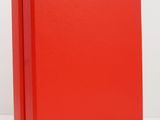 a close up of a red binder on a white surface