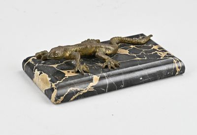 a statue of a lizard that is laying on top of a book
