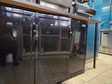 stainless steel double door freezer in commercial kitchen with tiled floor