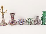 five different vases and a lamp on a white surface
