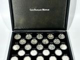 une boîte noire contenant douze pièces d'argent, sur fond blanc