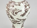 chinese white and brown vase with a dragon design on the outside