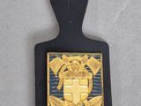une photo d'un insigne noir et doré orné d'une croix