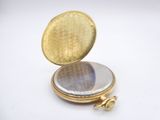 a small gold locke with a mirror inside of it