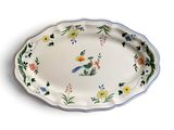 un grand plat ovale orné d'un oiseau et de fleurs