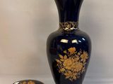 a blue vase with a gold decoration next to a small box