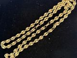 a pair of gold chain bracelets on a black surface