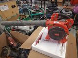un ventilateur rouge posé sur une boîte en carton