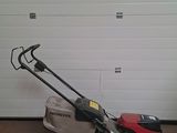 a lawn mower parked in front of a garage door