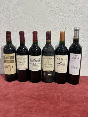 six bottles of wine are lined up on a table