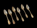 six silver spoons are lined up in a row on a black background