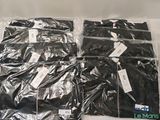four bags of black clothing sitting on a white surface