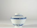 bol en porcelaine bleue et blanche avec couvercle, posé sur un fond blanc