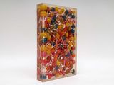 brightly colored lollipops in a clear box on a white background