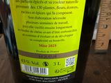 une bouteille de vin posée sur une table, à côté d'une règle