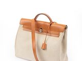 Le petit sac beige et marron clair est posé sur une surface blanche.