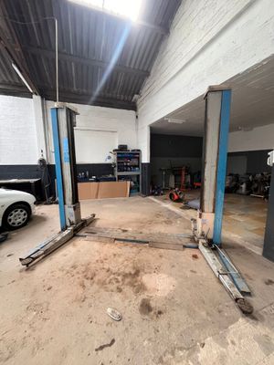 une photo d'un garage avec une voiture au milieu