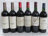 six bottles of wine are lined up in a row on a table