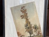 une image représentant un tableau représentant un arbre, dans un cadre posé sur une chaise