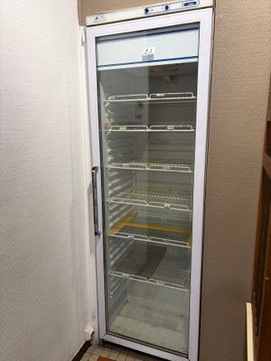 a refrigerator that is open in the corner of a room