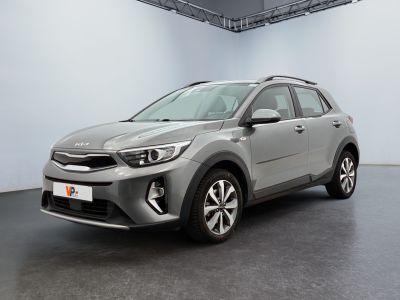 Une voiture grise est garée dans une grande pièce aux murs blancs.