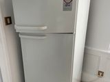 a white refrigerator in the corner of a room